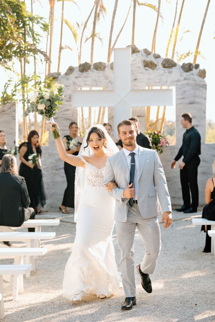 Bride and groom holding hands during outdoor Venice Florida wedding ceremony