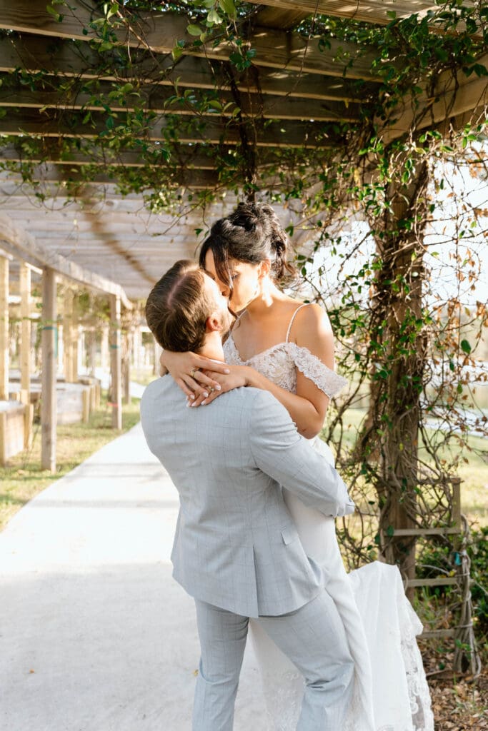 Bride and groom first kiss during outdoor Venice Florida wedding ceremony