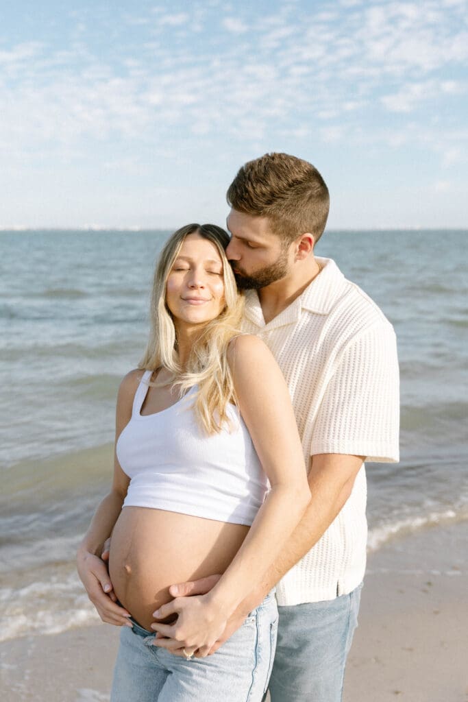 natural maternity photos florida couple walking shoreline barefoot