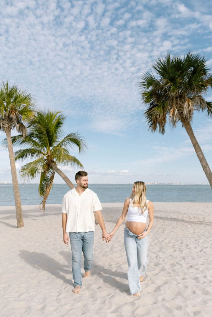 sanibel island maternity photos couple walking barefoot on beach