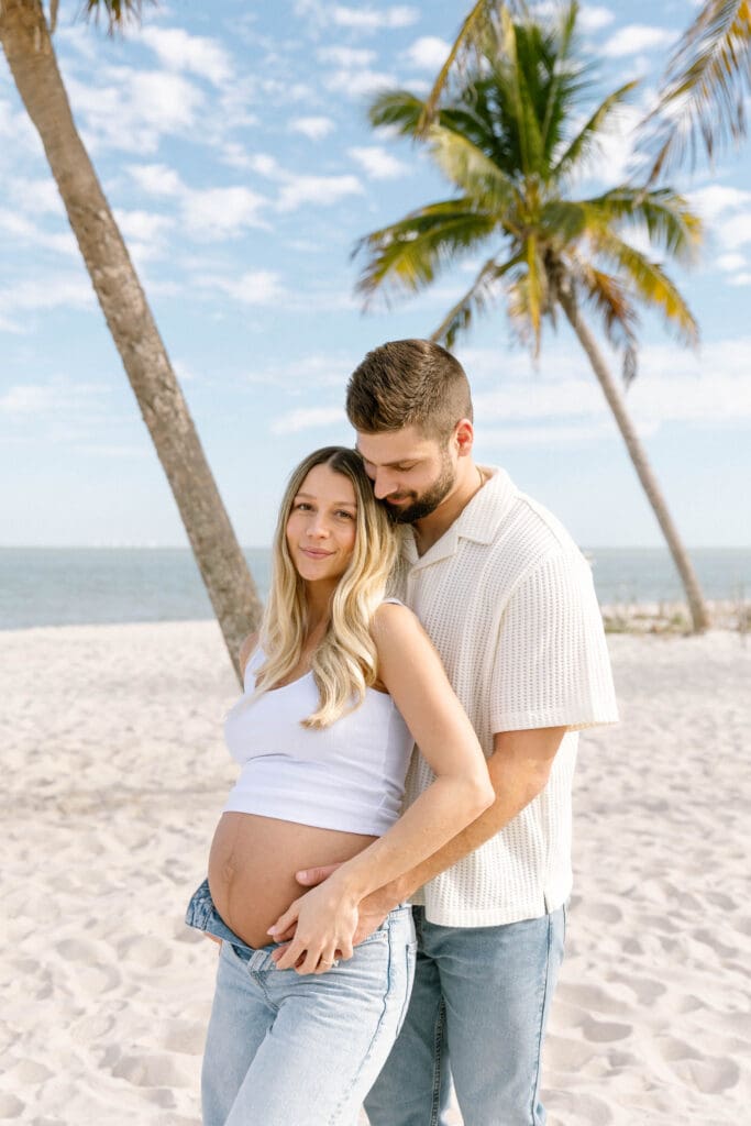 sanibel island maternity photos couple walking barefoot on beach