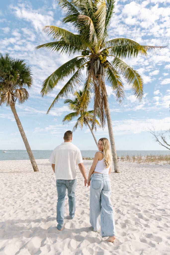 sanibel island maternity photos couple walking barefoot on beach