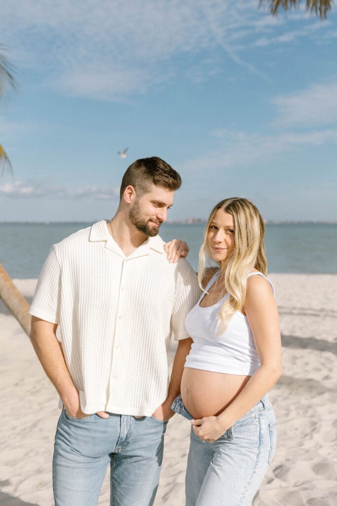 florida beach maternity session couple holding hands at sunset