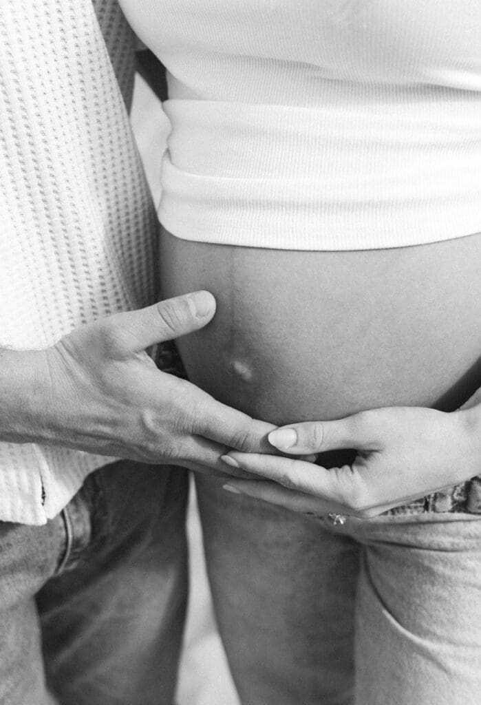 romantic maternity photos beach couple embracing ocean background