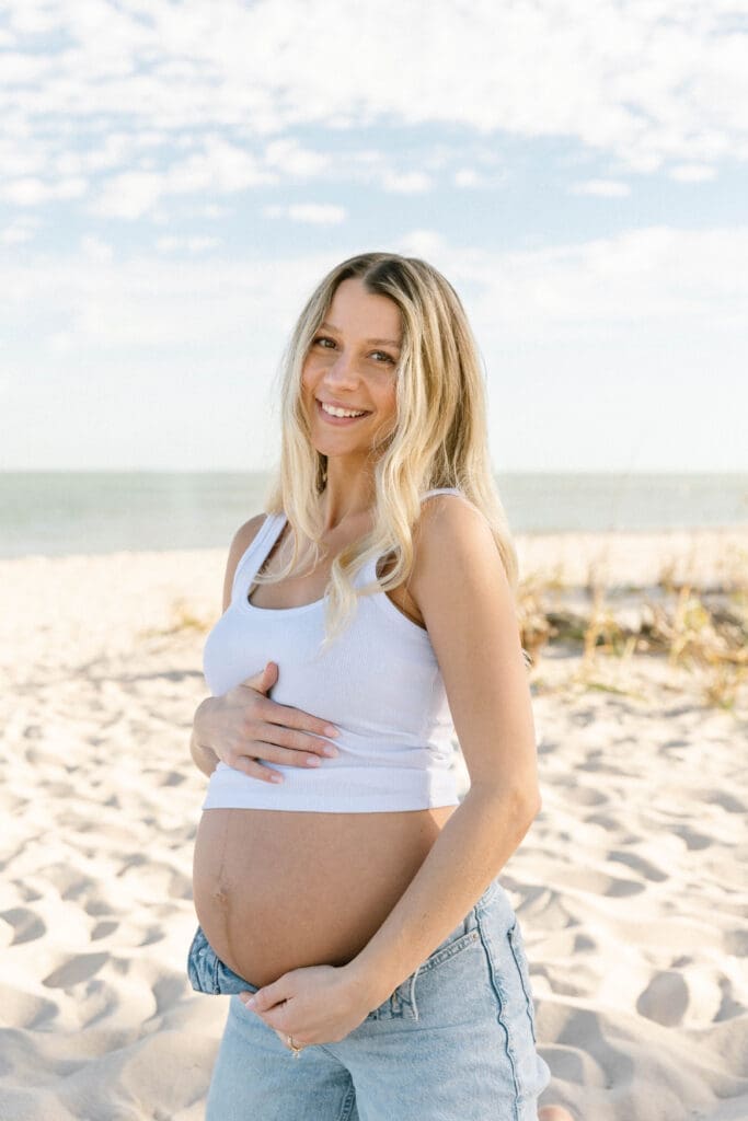 romantic maternity photos beach couple embracing ocean background